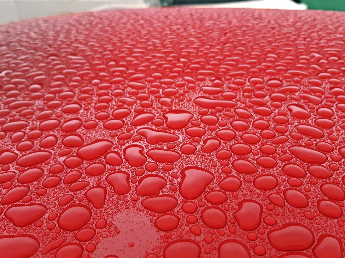 Water beading on a freshly protected red car roof